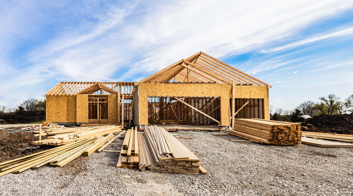 picture of home frame construction zone with inventory on front lawn